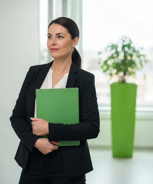 Business owner standing in an office hallway holding a folder while weighing a new IT provider decision